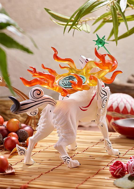 Back perspective lifestyle shot of the Amaterasu figure on a bamboo display under hanging green leaves, emphasizing the dramatic silhouette of the translucent flames.