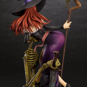 Side-back view of the Sorceress figure with her hat, posed leaning over the skeleton, highlighting the texture of her hair and outfit.