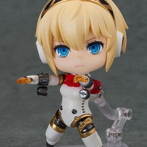 Nendoroid Aigis 2.0 figure in a dynamic combat pose with a serious face, firing the small orange shooting effect part from her arm.