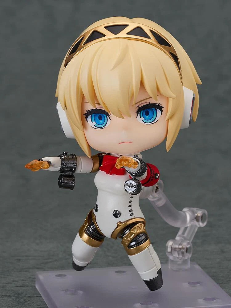 Nendoroid Aigis 2.0 figure in a dynamic combat pose with a serious face, firing the small orange shooting effect part from her arm.
