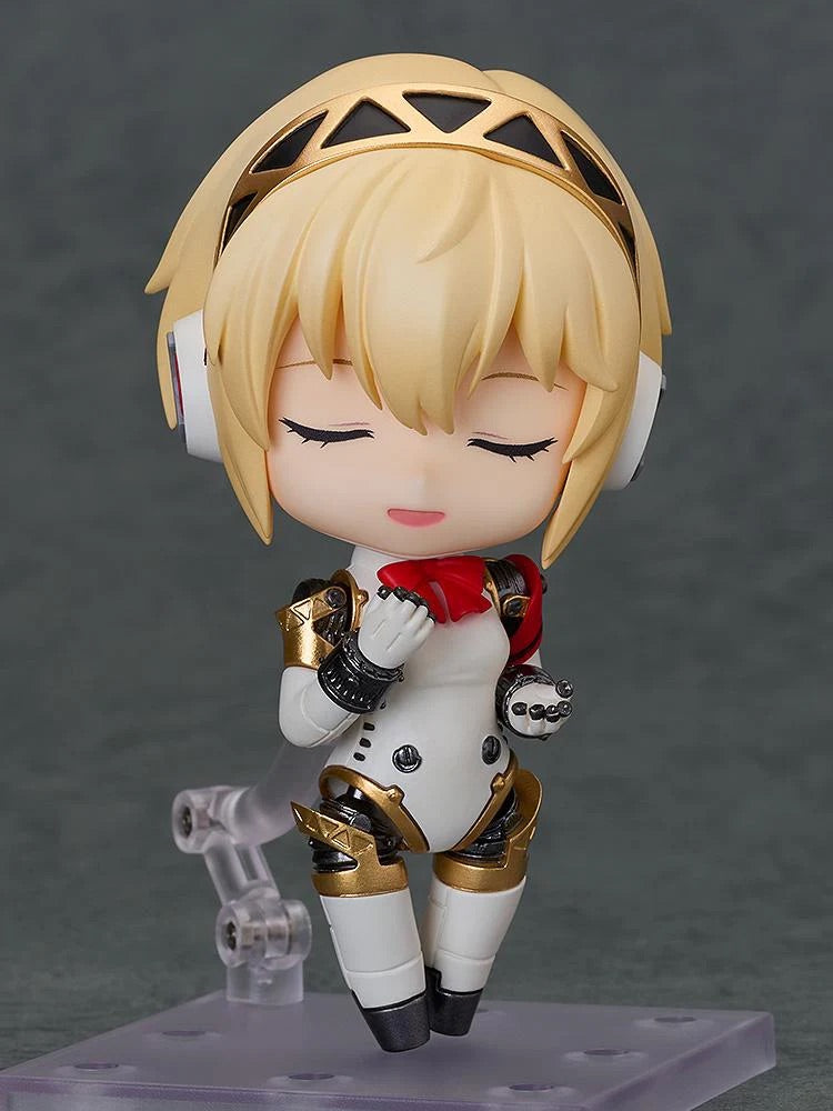 Nendoroid Aigis 2.0 figure with the smiling face plate, posed sweetly with her hands near her chest.