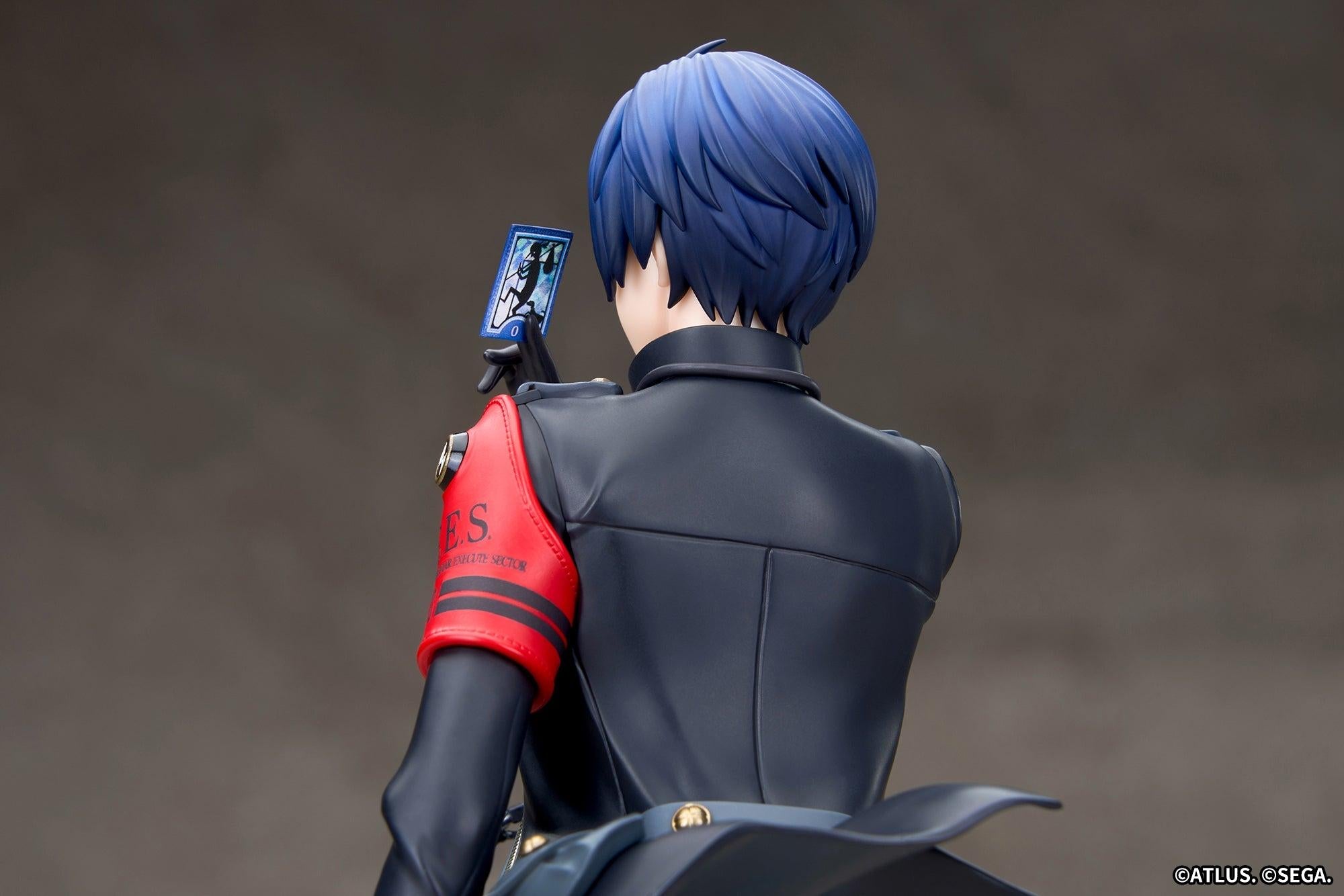 Rear perspective of the Persona 3 Reload Protagonist figure displaying the back of his blue hair and the Fool arcana tarot card.