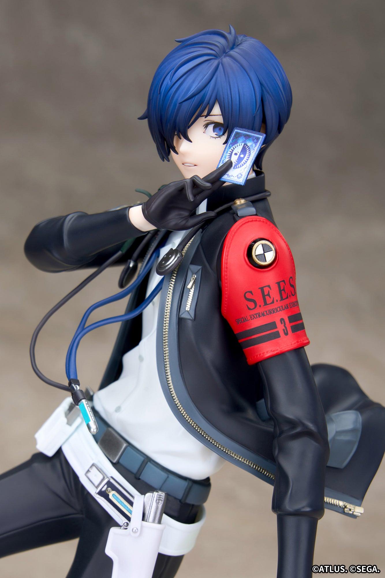 Close-up portrait of the Persona 3 Reload Protagonist figure holding a blue tarot card beside his face with red S.E.E.S. armband.