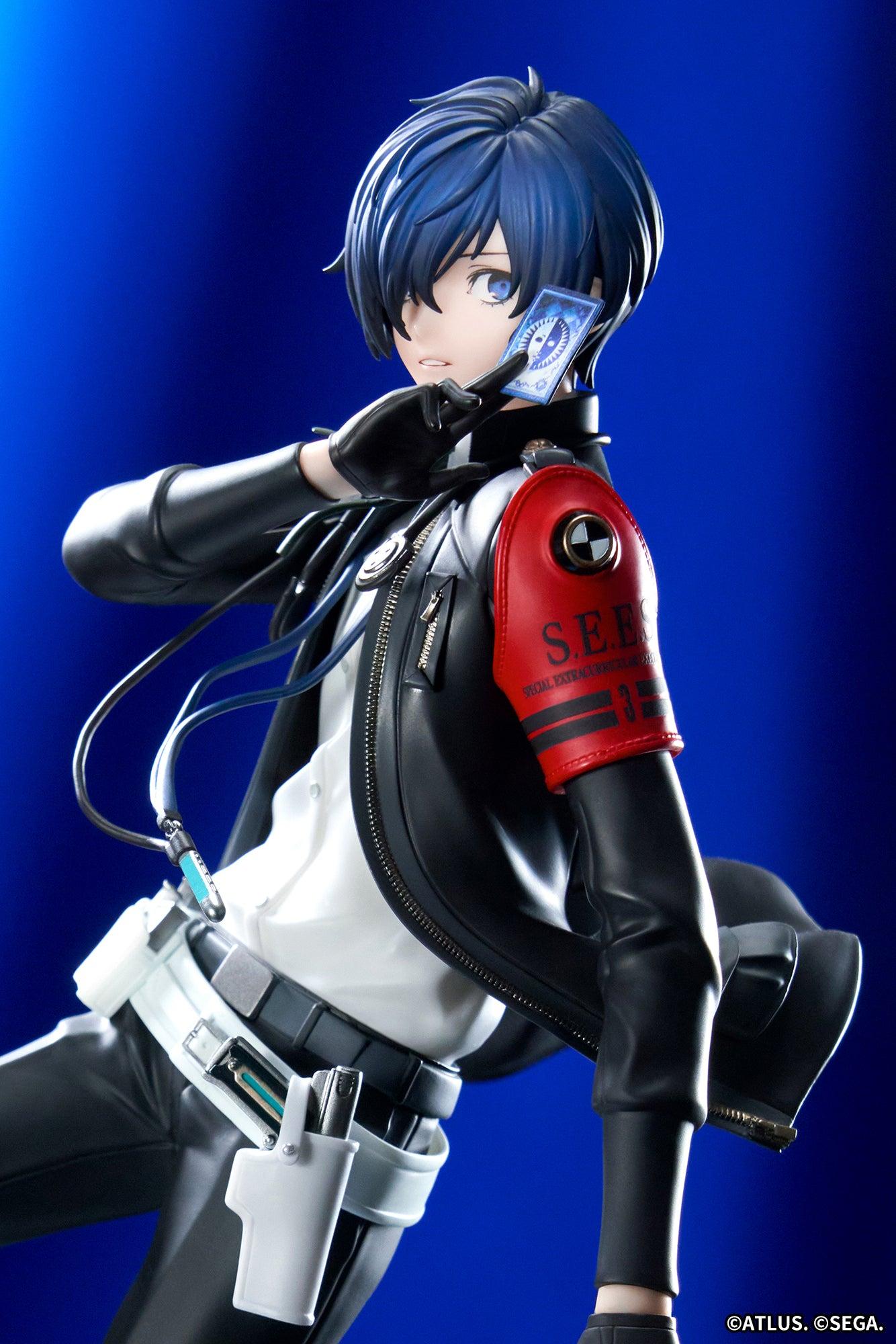 Portrait view of the Persona 3 Reload Protagonist figure showcasing facial sculpt, earphones, and red S.E.E.S. armband in blue lighting.