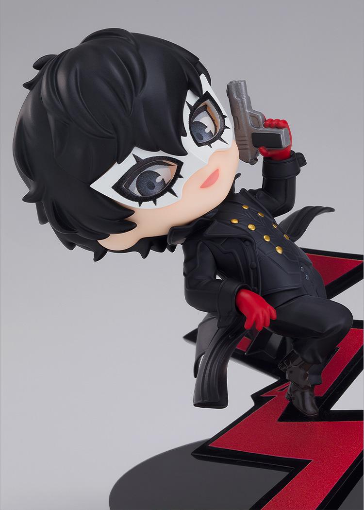 Close-up view of the Persona 5 Joker Nendoroid figure aiming a gun and wearing his mask over a red jagged path background.