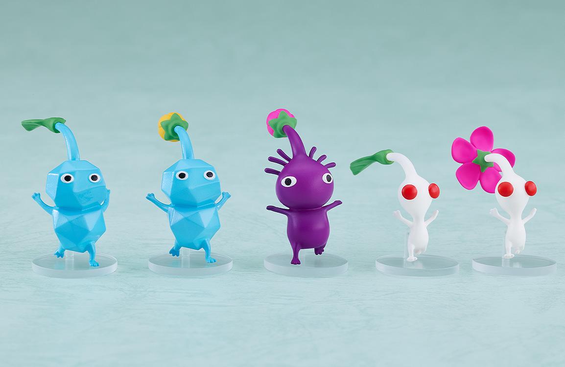 A lineup of the included Pikmin accessory figures, including Blue, Purple, and White Pikmin in various stages of growth.