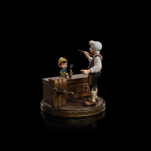 A full shot of the Iron Studios Pinocchio and Geppetto 1/10 scale statue, showing the complete scene against a dark, reflective background.