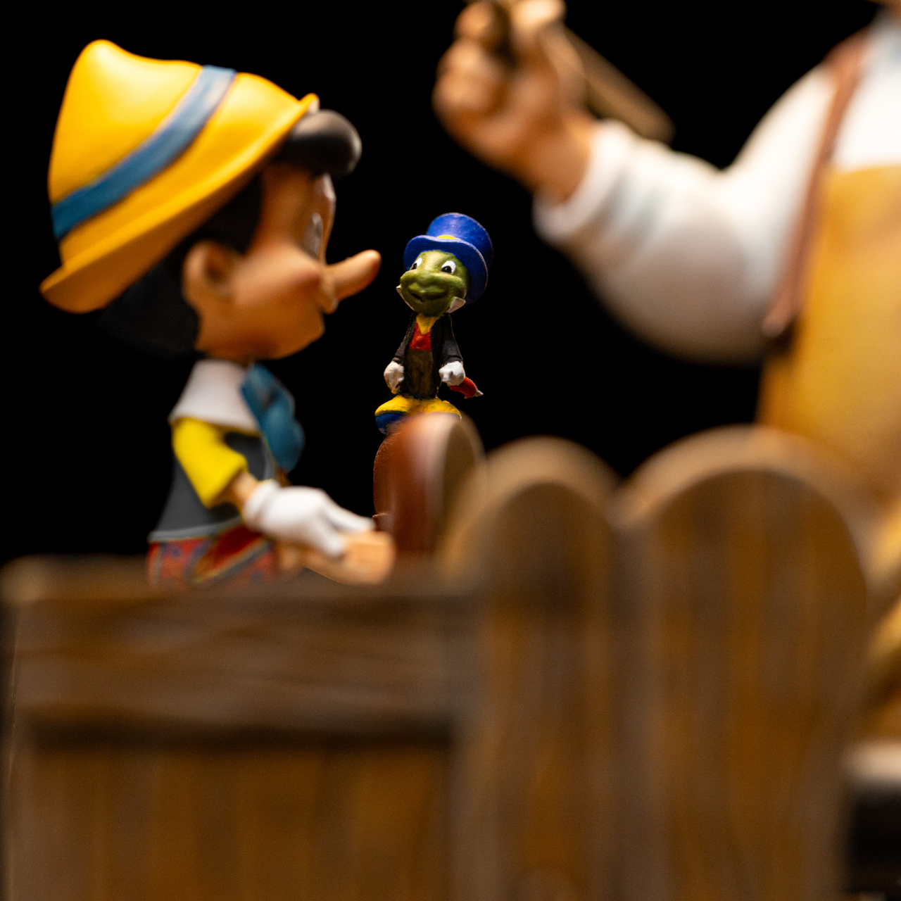 A detailed close-up of the Pinocchio figure and Jiminy Cricket on the workbench from the Iron Studios Pinocchio statue.