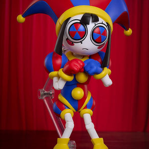 Highly articulated Pomni figma figure showing her frightened face plate with pinwheel eyes, clenching her gloved fists nervously against a deep red velvet curtain backdrop.