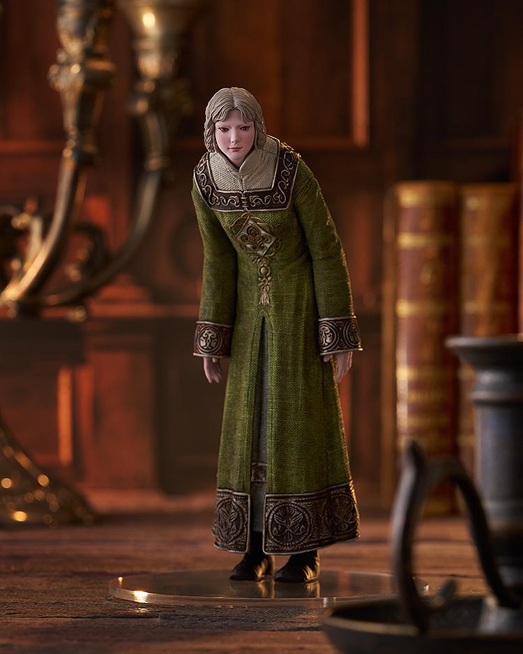 Rya figure from Elden Ring displayed in a library setting with books and a candle holder.
