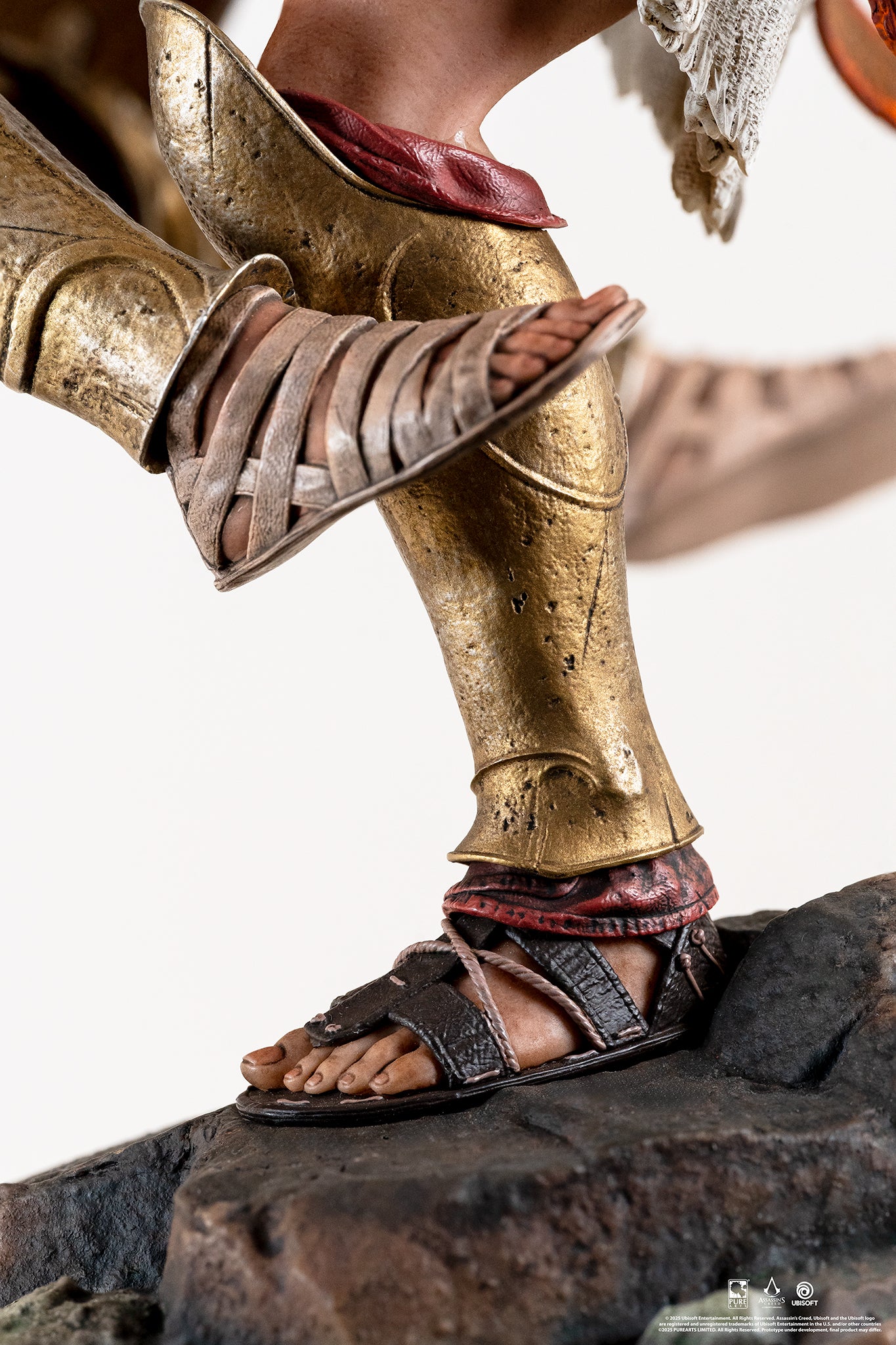 Extreme close-up of Alexios' foot making contact with the Athenian soldier's sandal, showcasing the detailed gold greaves and leather straps.