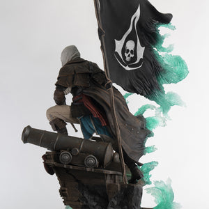 Back-left profile of the Animus Edward Kenway statue, showing the details of Edward's coat and the ship base from behind.