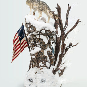A rear view of the Animus Connor statue, focusing on the wolf and the detailed snowy rock bluff of the base, with Connor partially visible.