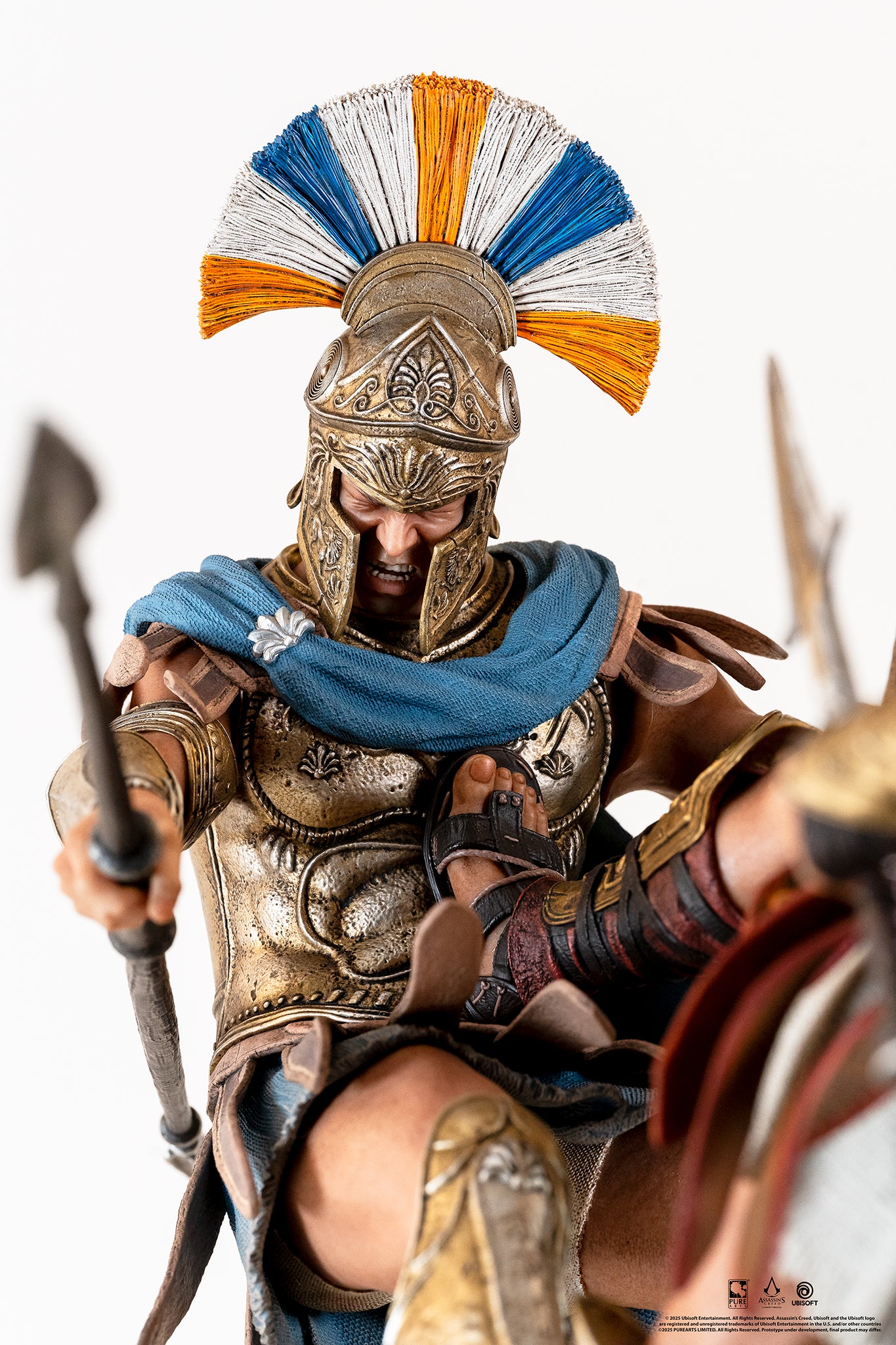 Close-up portrait of the Athenian Commander's face, showing his yelling expression and the blue/orange plumed helmet.