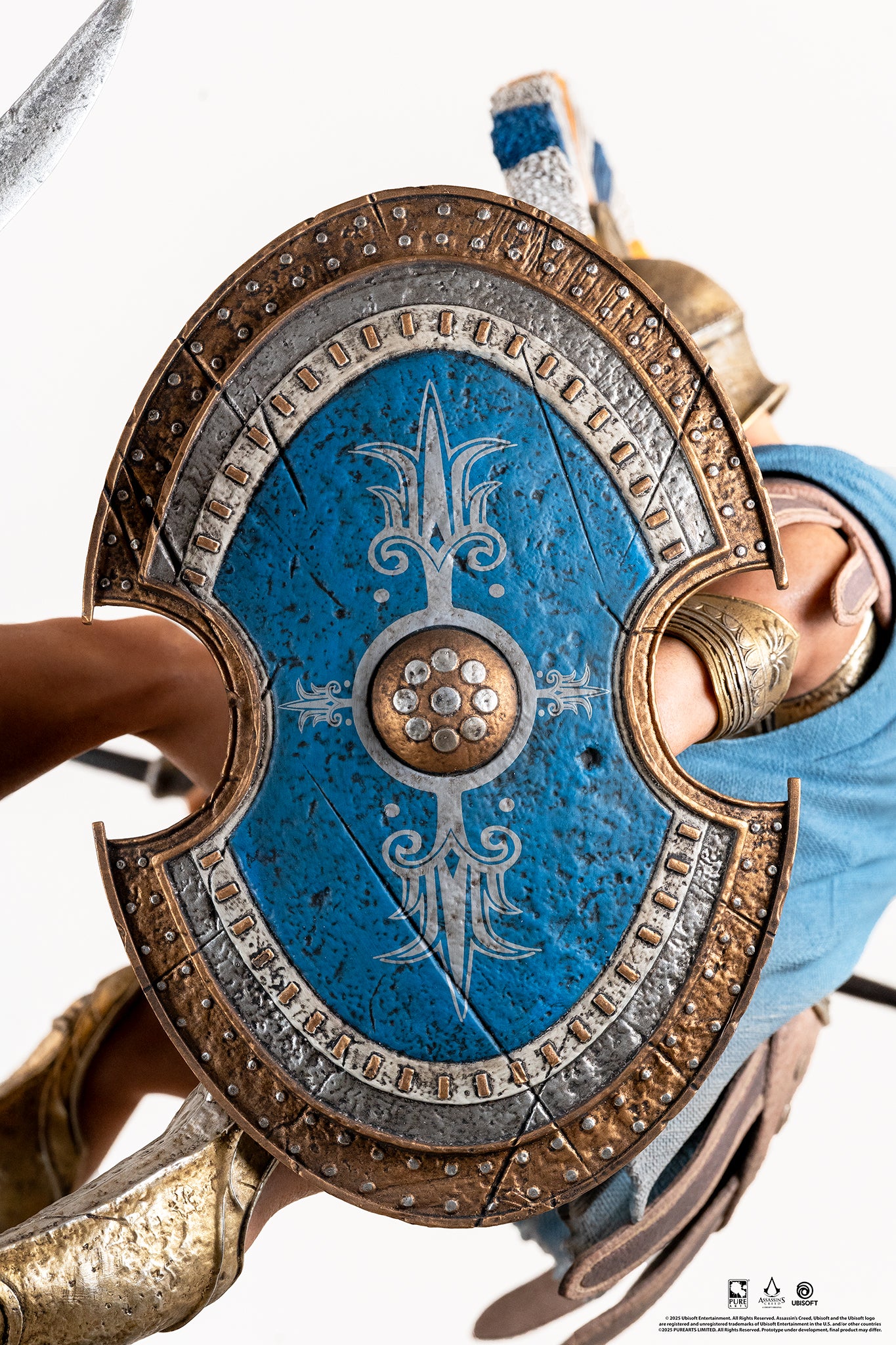 Close-up of the Athenian Commander's shield, showing its large size and the intricate blue, silver, and gold painted design.