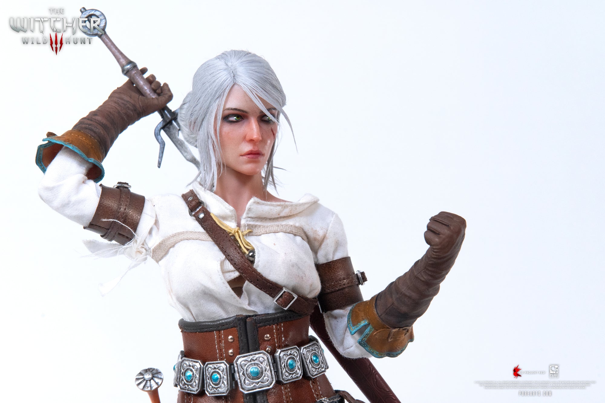 Close-up of the Ciri figure posed with her arm raised above her head, as if drawing her metal sword.
