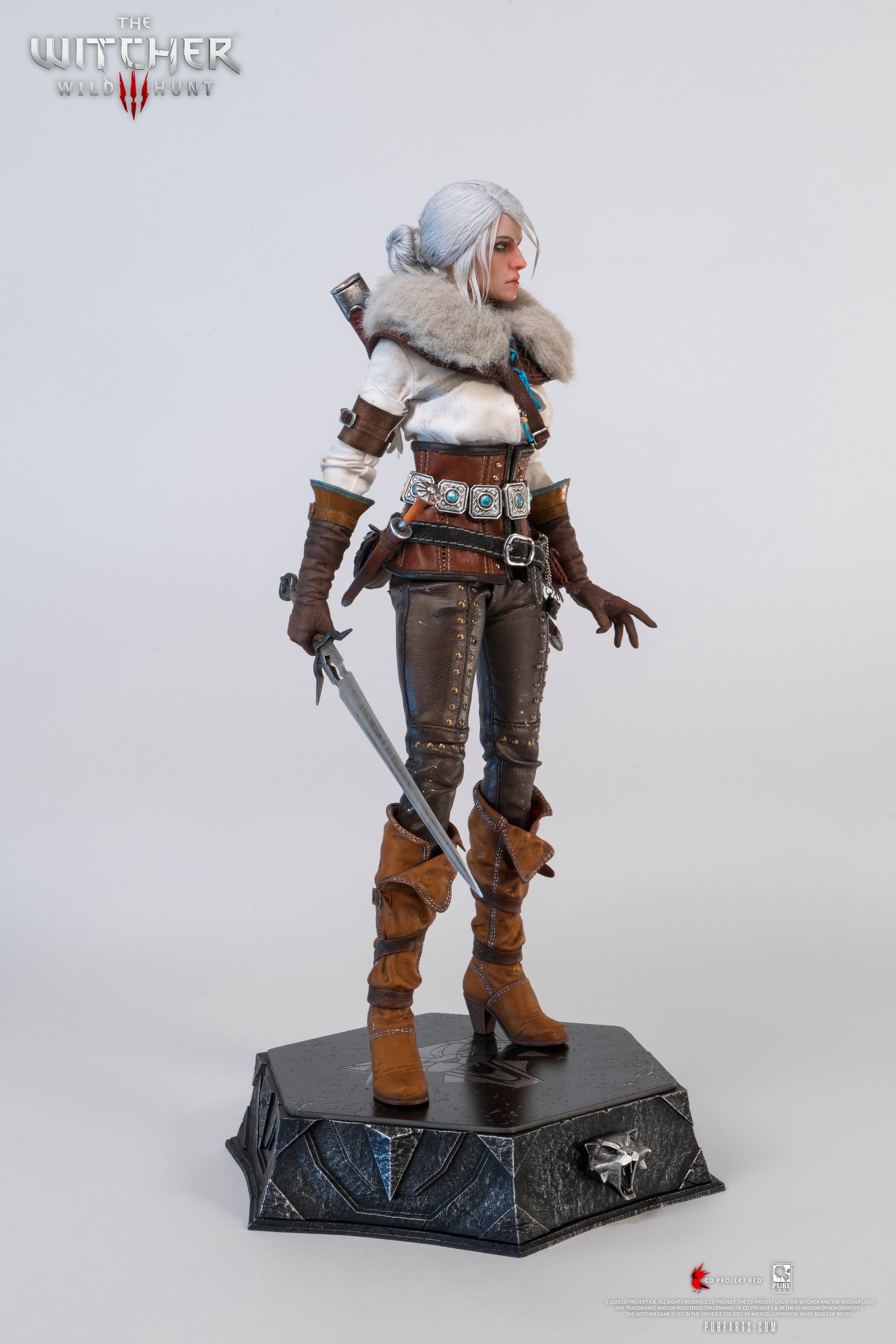 A slightly angled frontal view of the Ciri figure, wearing the fur mantle and holding the metal sword down in front of her.