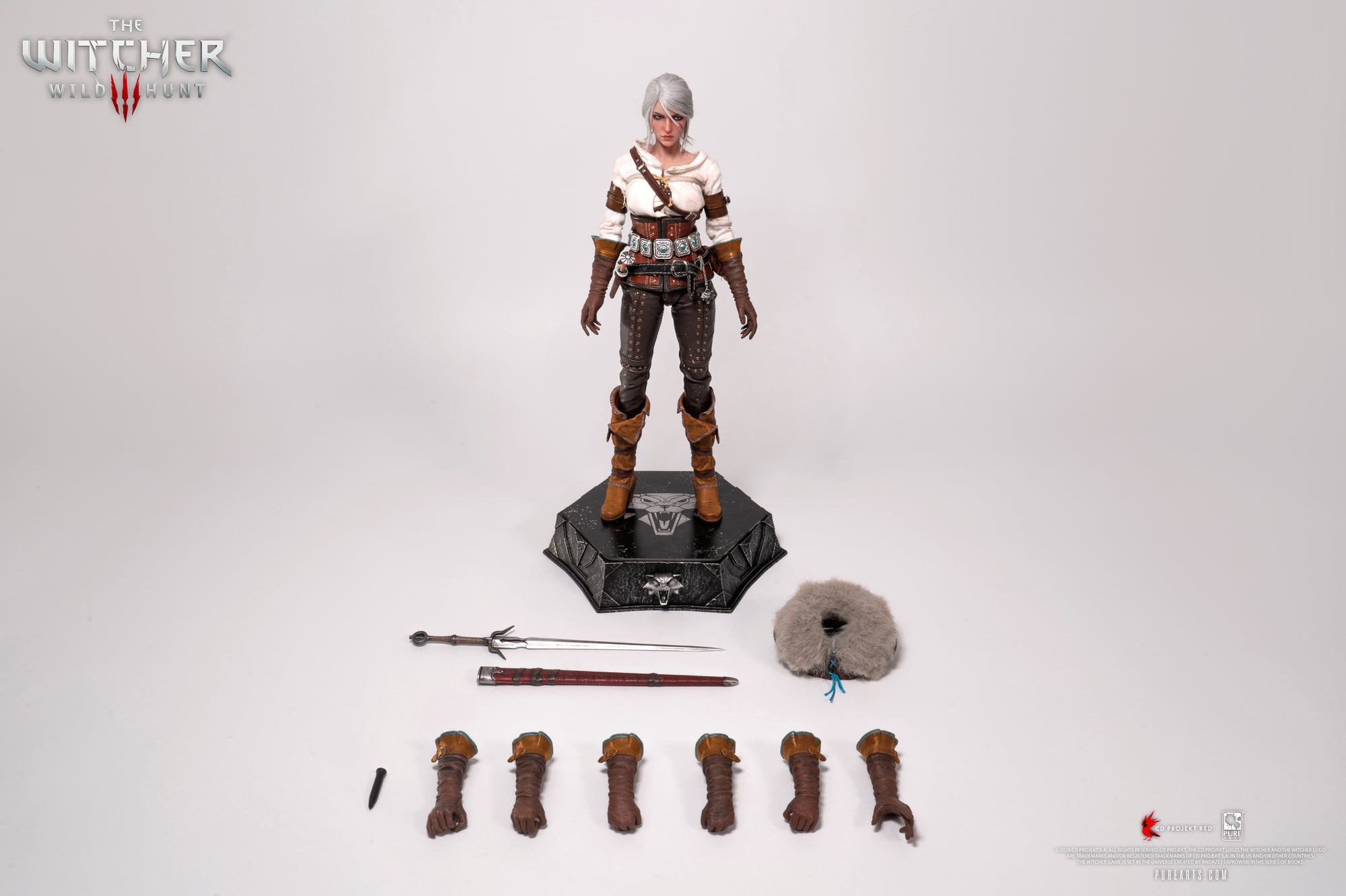Laydown shot of the Ciri figure with all major accessories detached: sword, scabbard, dagger, fur mantle, swappable hands, and adjustment tool.