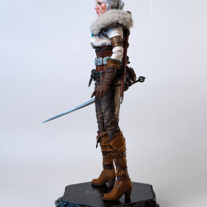 Side profile of the Ciri figure wearing the fur mantle and drawing her metal sword.