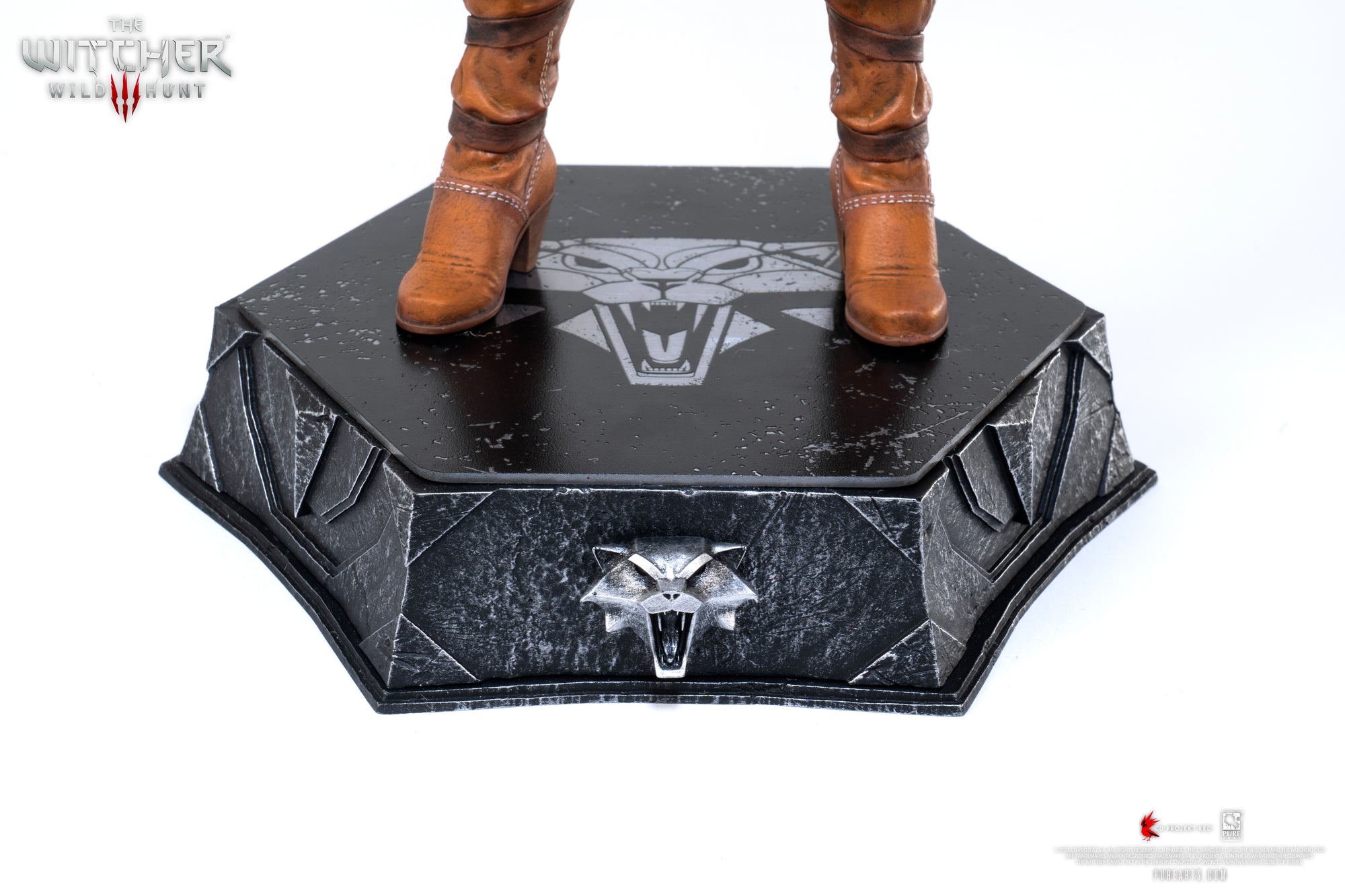 Close-up of Ciri's boots standing on the hexagonal base, highlighting the Witcher Wolf Medallion symbol etched onto the platform.