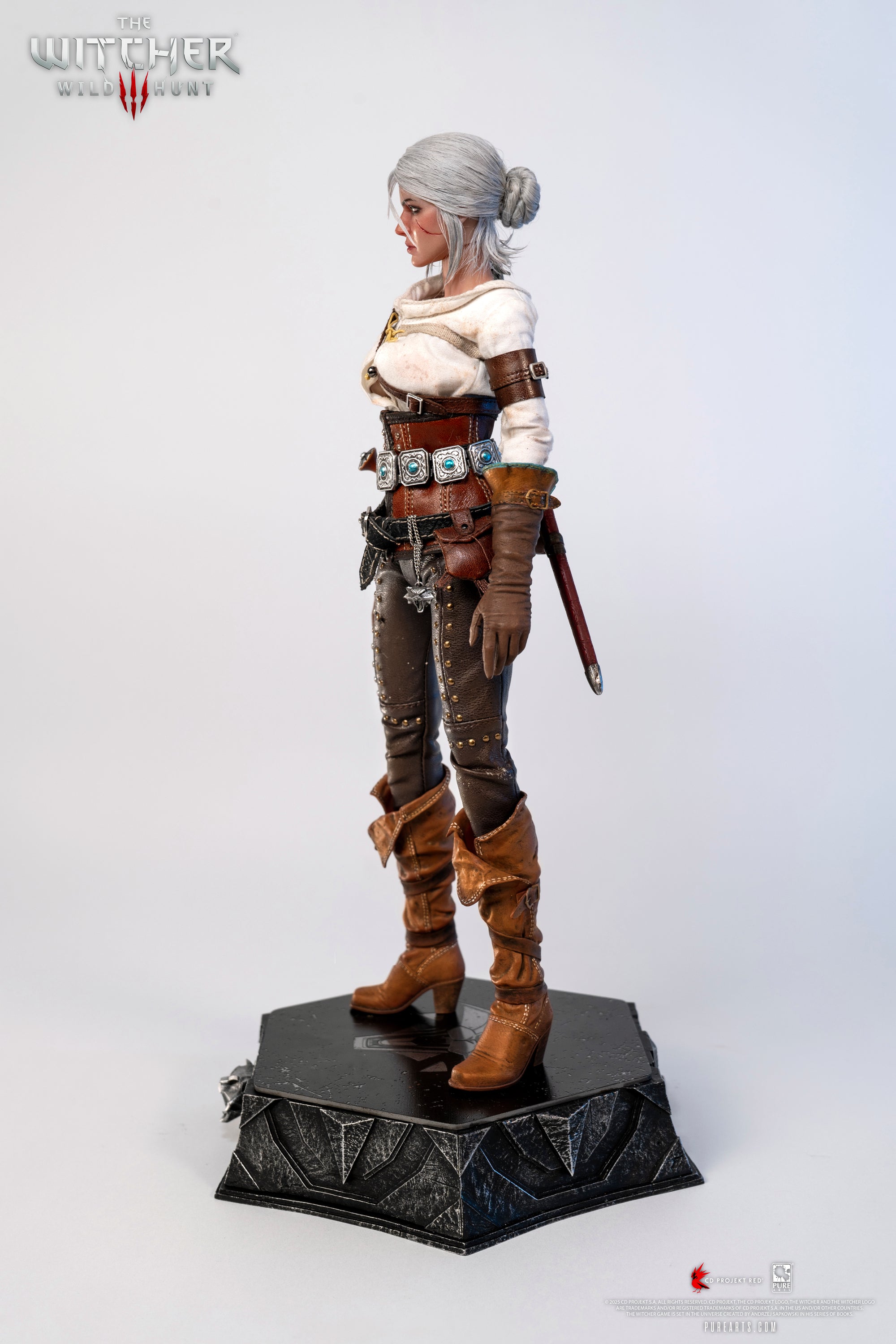 Side profile of the Ciri figure, showing her leather boots and the dagger handle tucked into her belt.