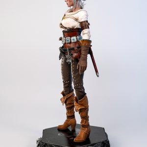 Side profile of the Ciri figure, showing her leather boots and the dagger handle tucked into her belt.