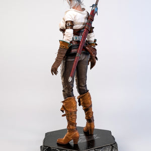 A three-quarter rear view of the Ciri figure, showcasing the back of her scabbard and her gray bun hairstyle.
