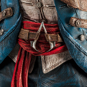 An extreme close-up of the midsection of the Animus Connor statue, focusing on the red sash and the classic Assassin's Creed logo on his belt buckle.