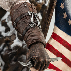 A detailed close-up of Connor’s forearm from the statue, showing his hand gripping his hidden blade and the intricate leather arm guard.