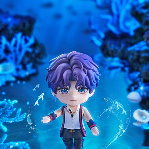Rafayel Nendoroid figure extending his hand in a bright blue underwater coral scene surrounded by glowing magical swimming fish.