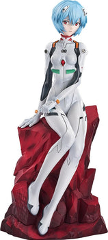 Full-length view of the Rei Ayanami 1/7 scale figure in her white 00 plugsuit, seated on a jagged red rock base.