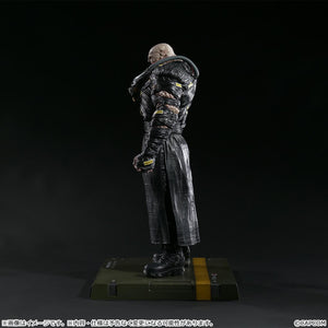 Side profile view of the Nemesis figure highlighting the mechanical tubing on the shoulder and the texture of the weathered black attire.