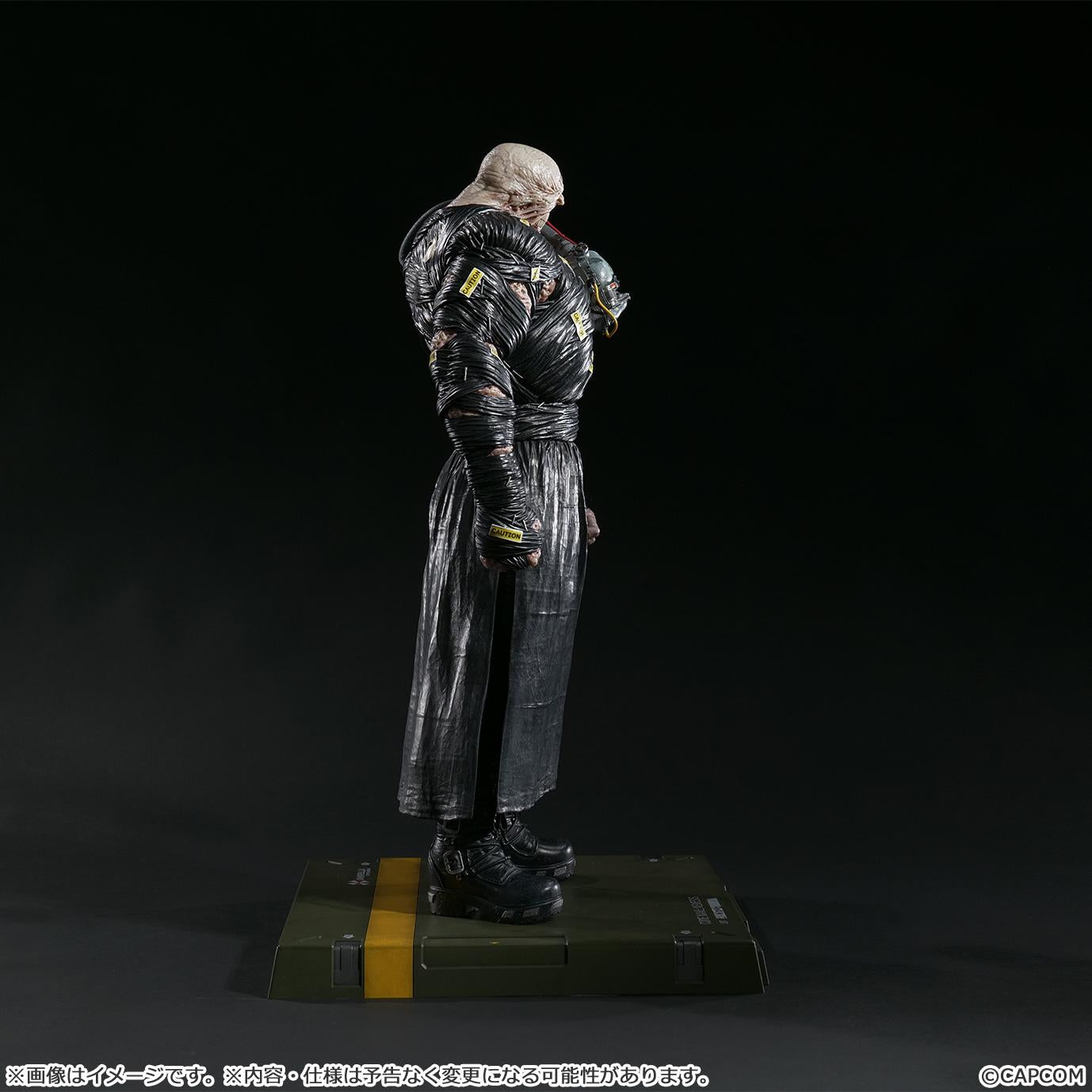 Side profile of the Nemesis statue against a black background, focusing on the character's hunched posture and massive scale.