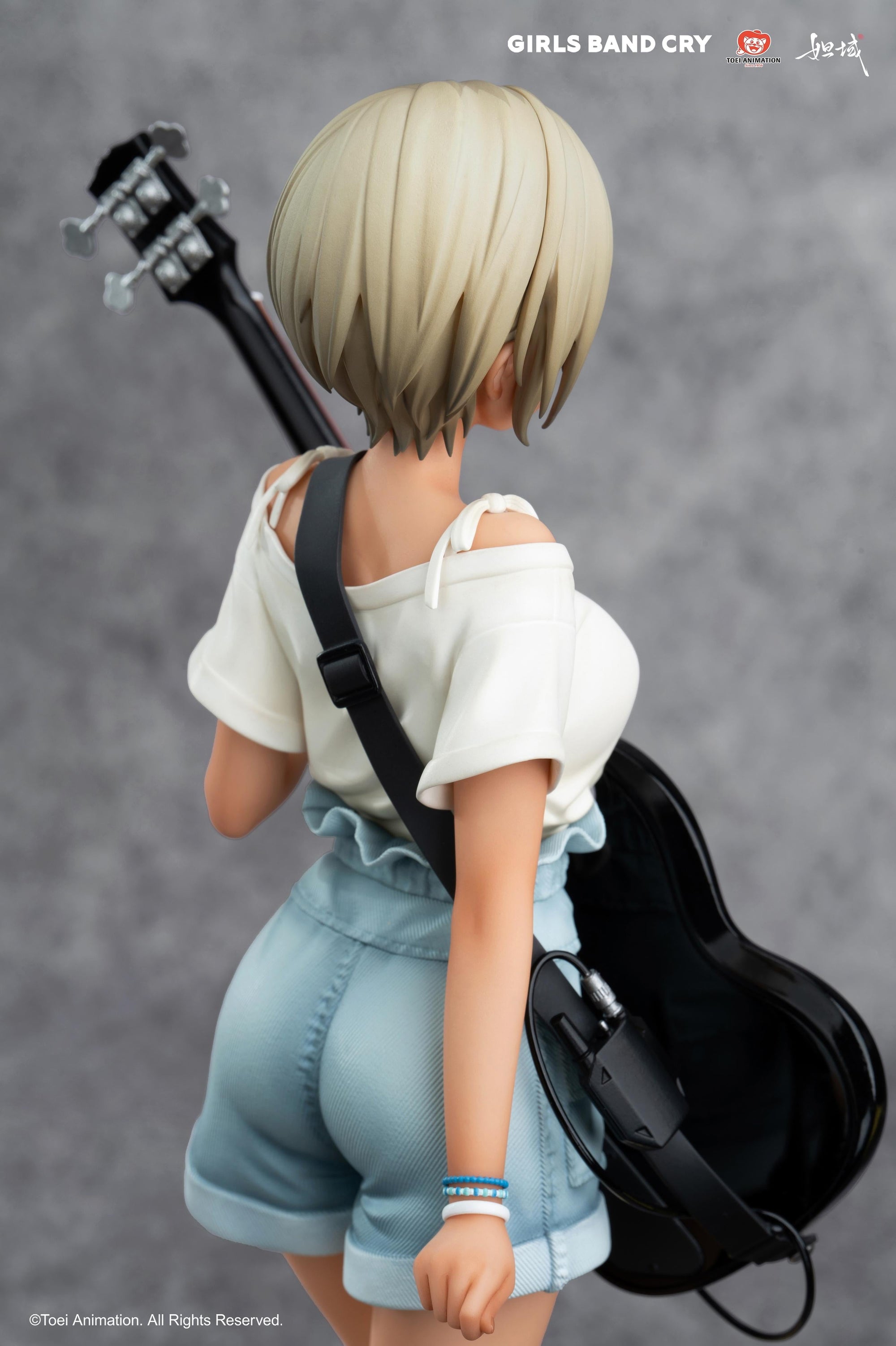 Detailed rear perspective focusing on the guitar strap and Rupa's short blonde hairstyle.