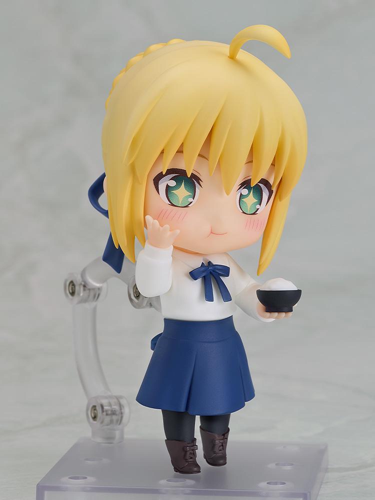 Standing Saber Casual Version Nendoroid figure holding a bowl of white rice with blushing cheeks and a delighted sparkling expression.