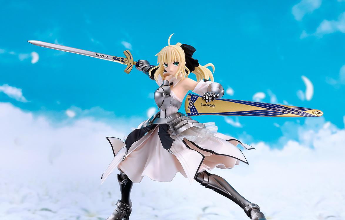 The completed Saber Lily Reincarnation model kit wielding Excalibur against a bright blue sky and clouds background.