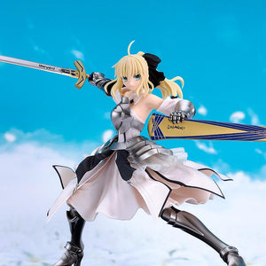 The completed Saber Lily Reincarnation model kit wielding Excalibur against a bright blue sky and clouds background.