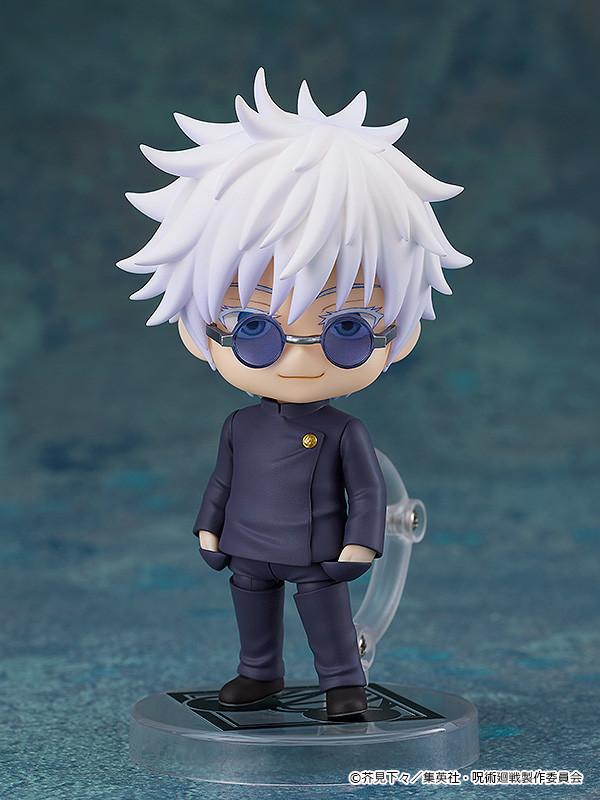 Full-body studio shot of the Satoru Gojo Nendoroid figure standing confidently on a custom clear base with a subtle smile while wearing his round sunglasses.