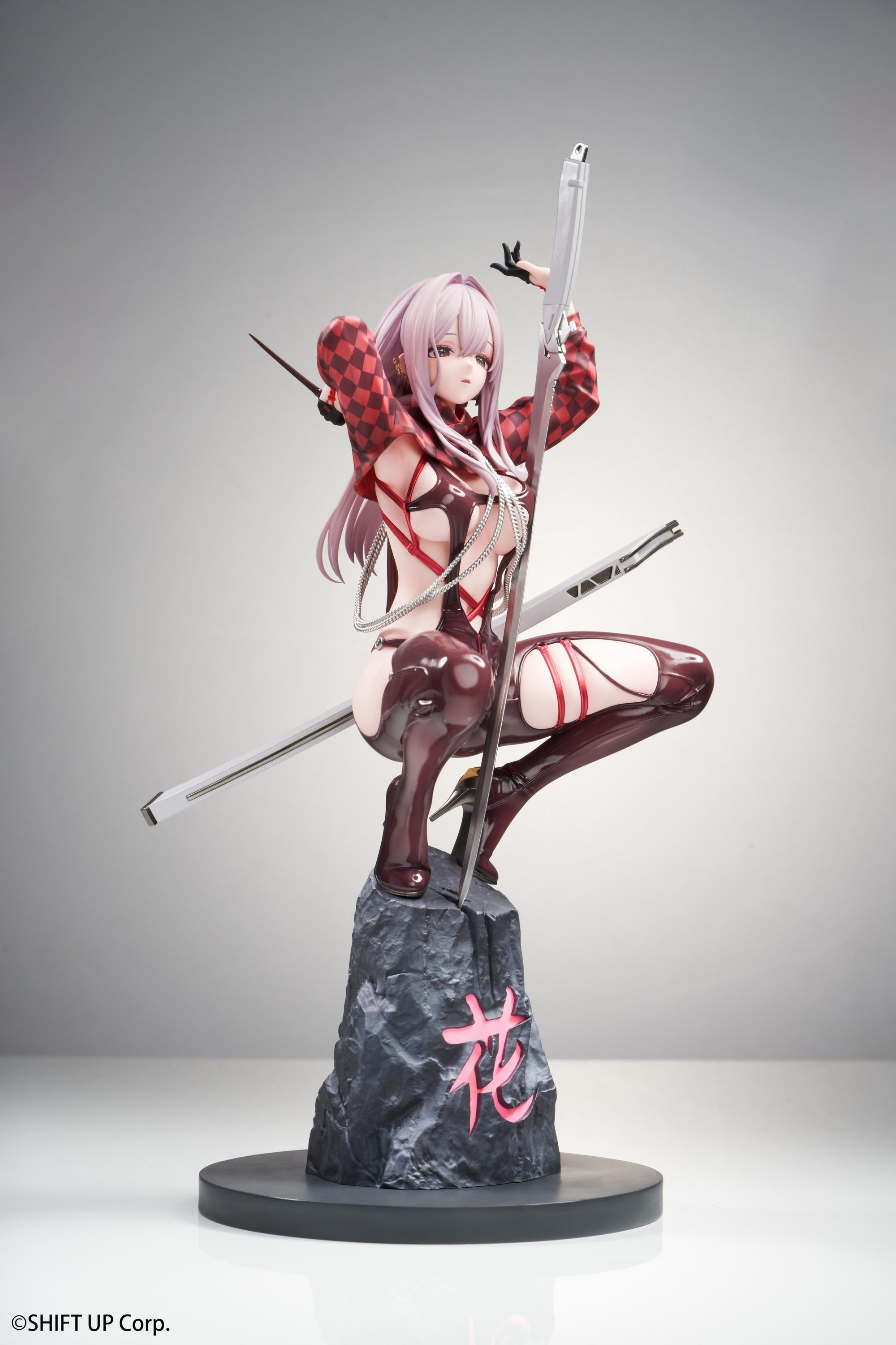 Angled right view of the Scarlet scale figure posing with her weapon on the sculpted rock base.