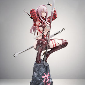 Angled right view of the Scarlet scale figure posing with her weapon on the sculpted rock base.