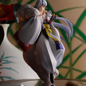 Cinematic shot of the Sesshomaru figure in a traditional Japanese room setting with floral accents and warm lighting.
