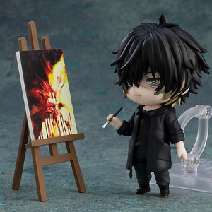 Towa Nendoroid figure holding a paintbrush next to a wooden easel and painted canvas.
