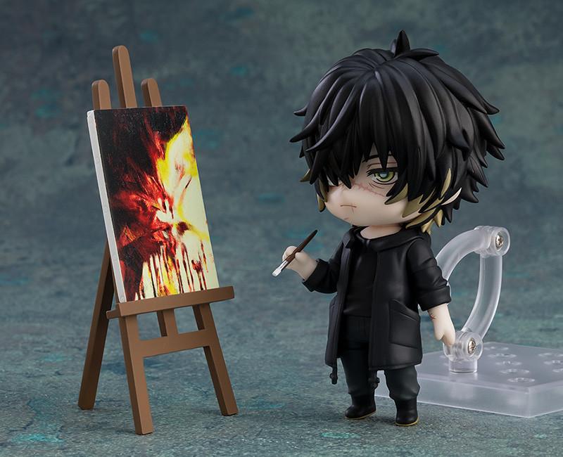 Towa Nendoroid figure holding a paintbrush next to a wooden easel and painted canvas.