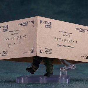 Iconic stealth pose of the Naked Snake Nendoroid hiding under a Good Smile Company cardboard box.