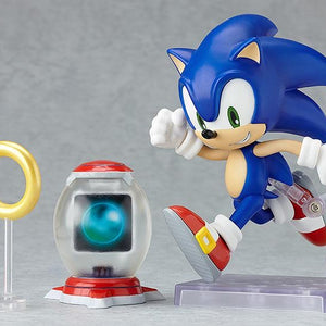 Nendoroid Sonic the Hedgehog figure posed running next to the gold ring accessory and the item box accessory.