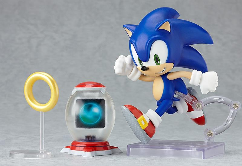 Nendoroid Sonic the Hedgehog figure posed running next to the gold ring accessory and the item box accessory.