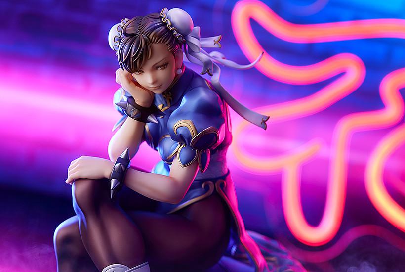 Close-up promotional image of Chun-Li statue with atmospheric neon light and smoke effects.