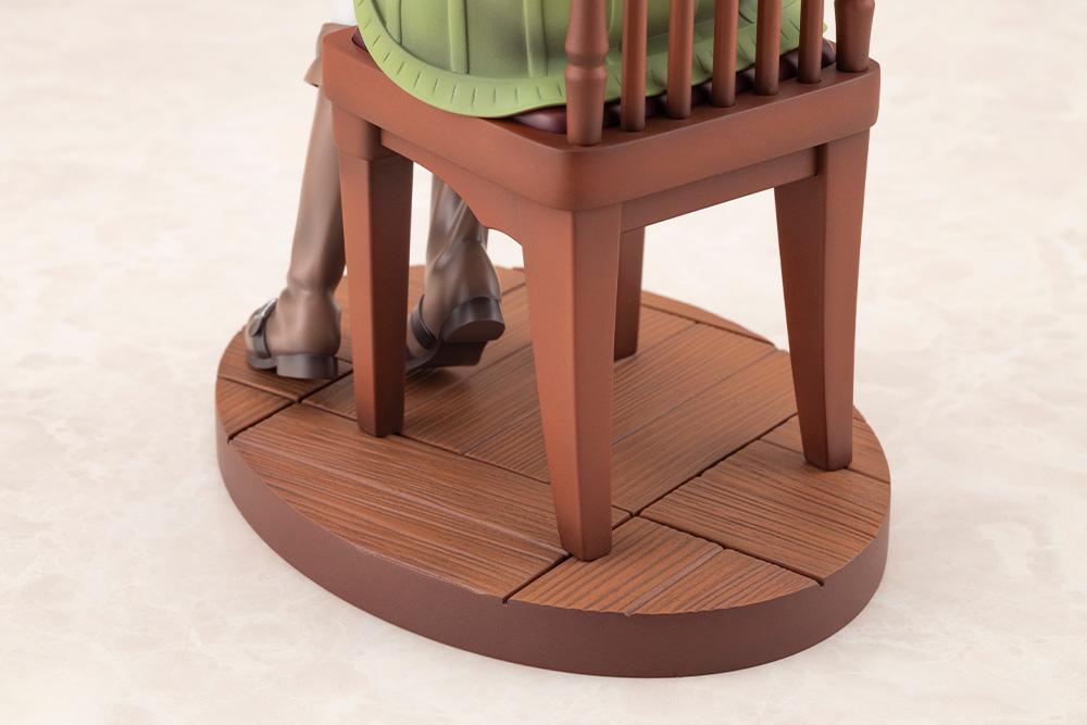 Close-up view of the sculpted wood-grain circular display base and wooden chair legs.