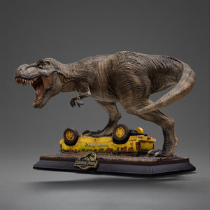 Full side profile view of the Iron Studios limited edition T-Rex Attack statue, showing the long tail curve and the prehistoric predator crushing the overturned jungle explorer car.