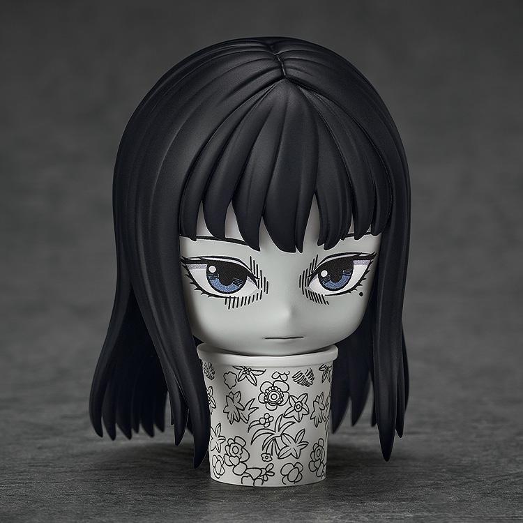 Close-up of Nendoroid Tomie with a displeased face plate displayed inside the floral trash can accessory.